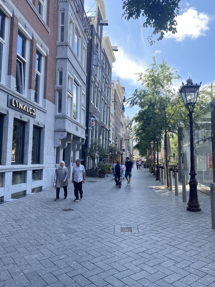 Une rue piétonne d'Amsterdam, bordée de maisons de briques et d'un lampadaire ancien